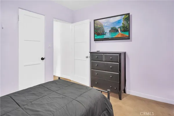 a bedroom with a bed and a painting on the wall
