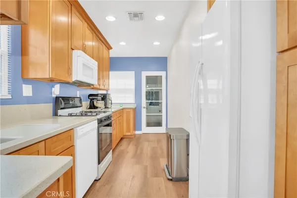 a kitchen with stainless steel appliances granite countertop a sink and a refrigerator