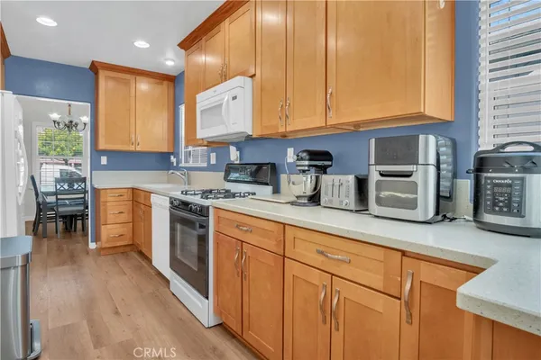 a kitchen with cabinets wooden floor and stainless steel appliances