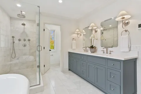 a bathroom with a double vanity sink mirror and shower