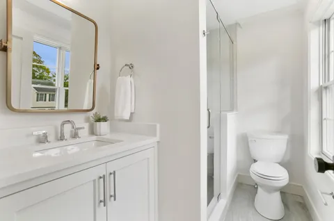 a bathroom with a toilet sink and mirror