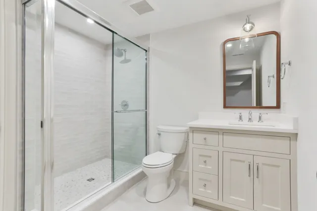 a bathroom with a toilet sink shower and mirror