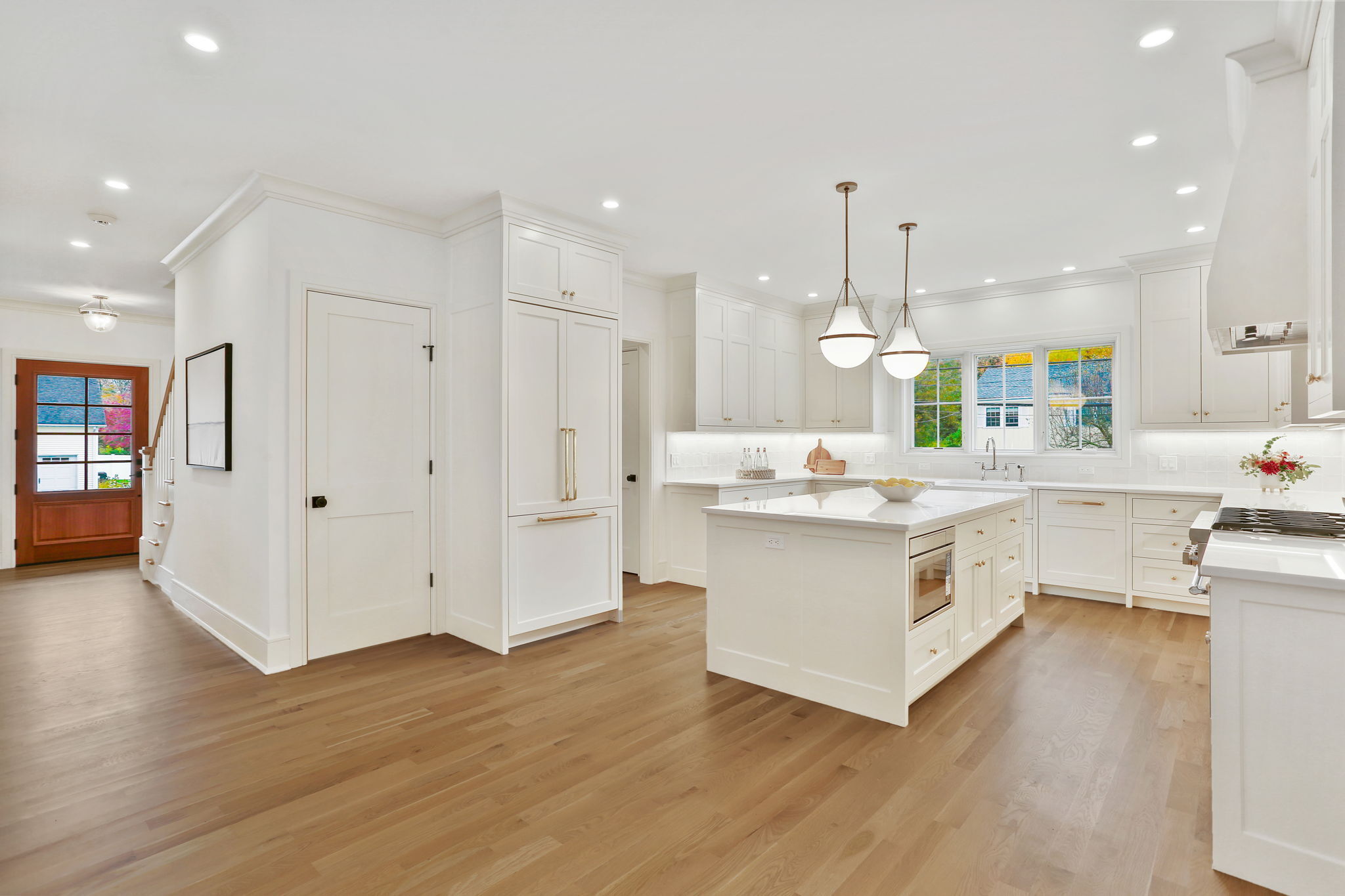15 Barton Road Fairfield, CT 06824 - Photo 10 of 39 a large white kitchen with kitchen island a chandelier stainless steel appliances cabinets and wooden floor