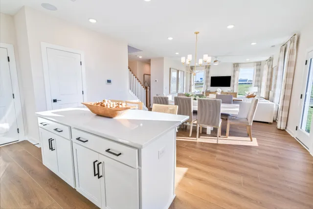 a kitchen with stainless steel appliances sink microwave stove refrigerator and wooden floor