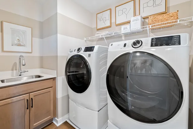 a utility room with dryer washer and a view of living room