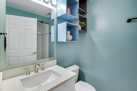 a bathroom with a toilet sink and mirror