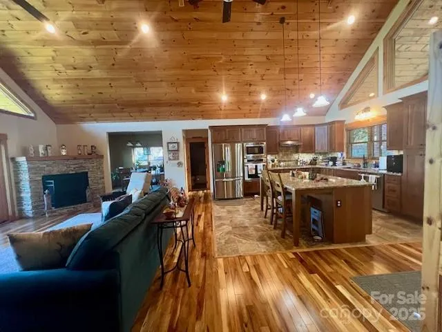a living room with stainless steel appliances kitchen island granite countertop furniture wooden floor and a kitchen view