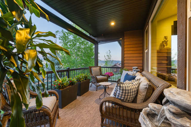 1737 East Viewside Circle Hideout, UT 84036 - Photo 12 of 35 Covered outdoor patio featuring wood-finish siding, a dark soffit ceiling, and a black wrought-iron railing