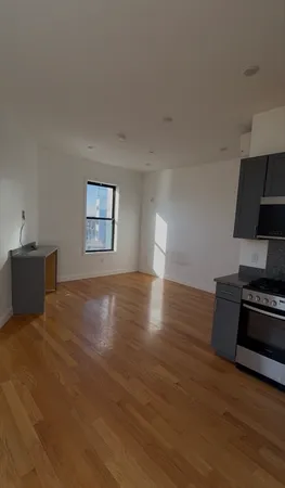 a view of a room with wooden floor and a window