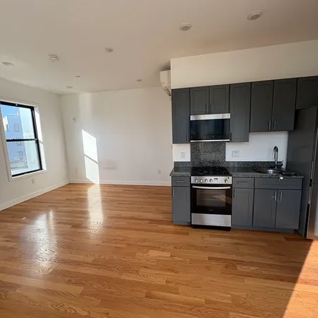 a kitchen with granite countertop a stove and a wooden floor