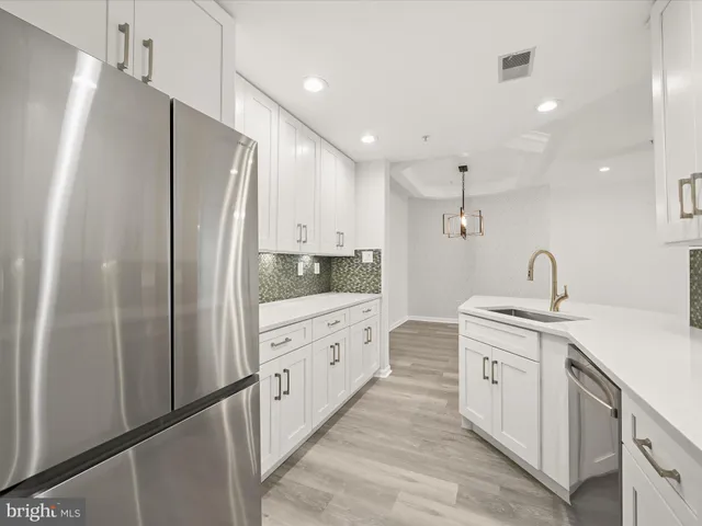 a large kitchen with stainless steel appliances a refrigerator and a sink