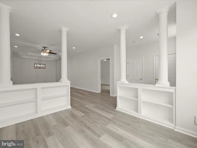 a view of an empty room and kitchen view