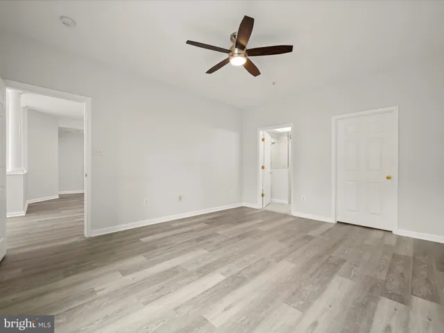a view of a livingroom with a ceiling fan and wooden floor