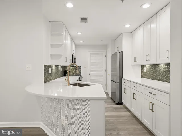 a kitchen with refrigerator and cabinets