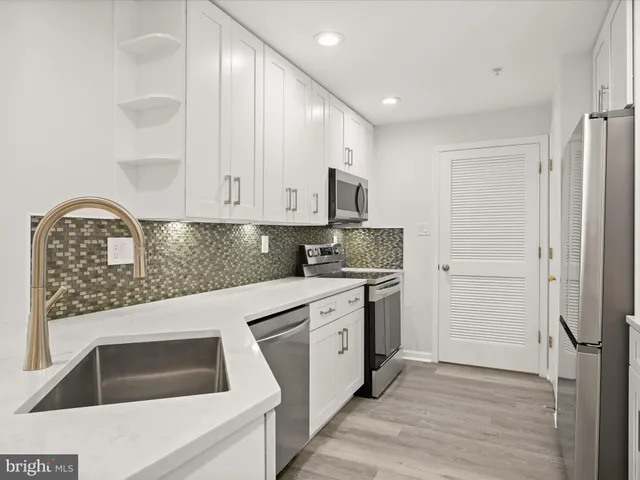 a kitchen with granite countertop white cabinets and white appliances