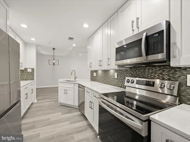 a kitchen with stainless steel appliances cabinets and a stove top oven