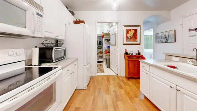 a kitchen with stainless steel appliances a stove top oven a sink a refrigerator and cabinets
