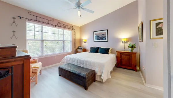 an empty room with windows and fan