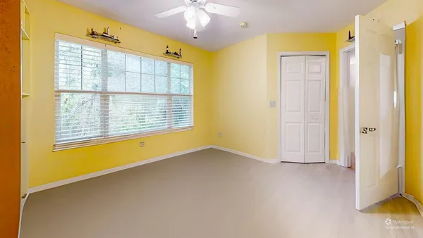 a spacious bedroom with a bed and a lamp