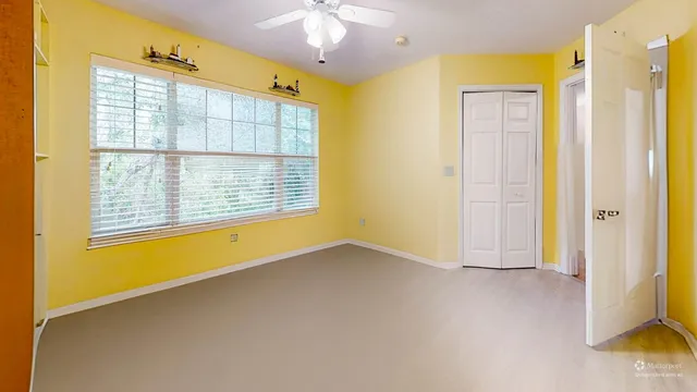 a spacious bedroom with a bed and a lamp