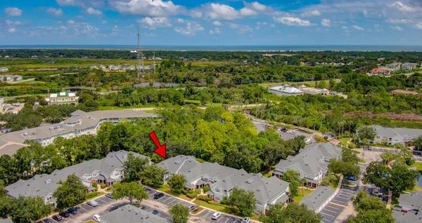 an aerial view of a house with a yard and a large tree
