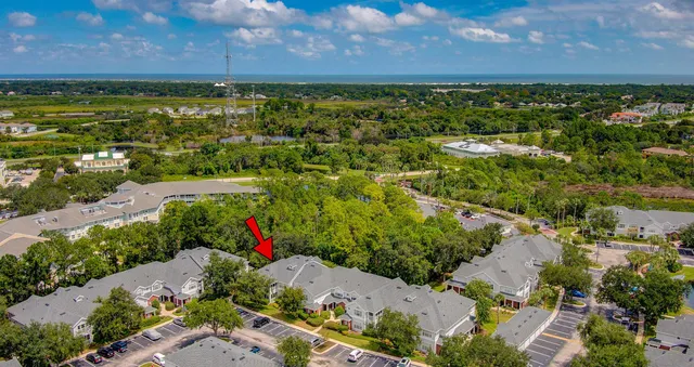 an aerial view of a house with a yard and a large tree