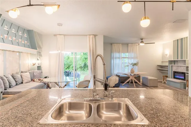 a kitchen with a sink a counter top space and living room view