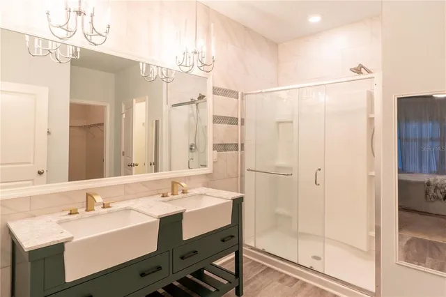 a bathroom with a shower sink vanity and mirror