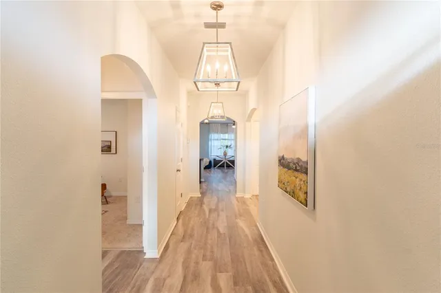 a view of a hallway with wooden floor and entryway