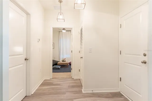 a view of a hallway with wooden floor and closet