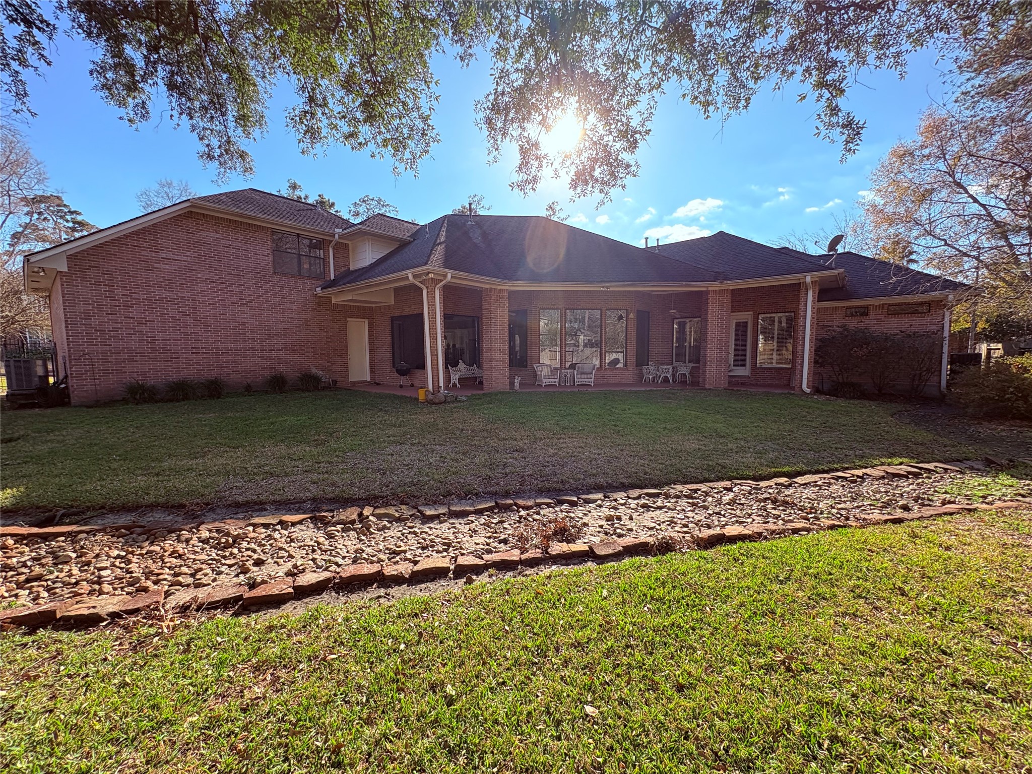 24602 West Kingscrest Circle Spring, TX 77389 - Photo 2 of 15 a view of a big house with a big yard and large trees
