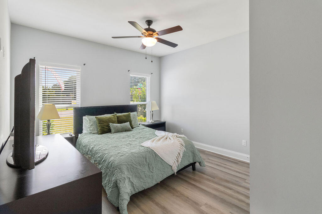 57 5th Street Shalimar, FL 32579 - Photo 11 of 31 a bedroom with a large bed chandelier and a window