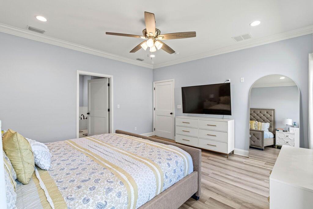 57 5th Street Shalimar, FL 32579 - Photo 20 of 31 a bedroom with a bed a flat screen tv and a chandelier
