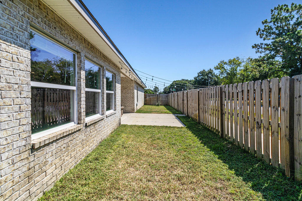 57 5th Street Shalimar, FL 32579 - Photo 28 of 30 a view of a backyard with wooden fence and large trees