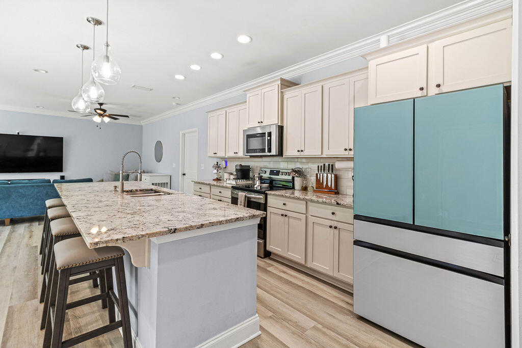 57 5th Street Shalimar, FL 32579 - Photo 4 of 30 a kitchen with kitchen island granite countertop stainless steel appliances and wooden cabinets