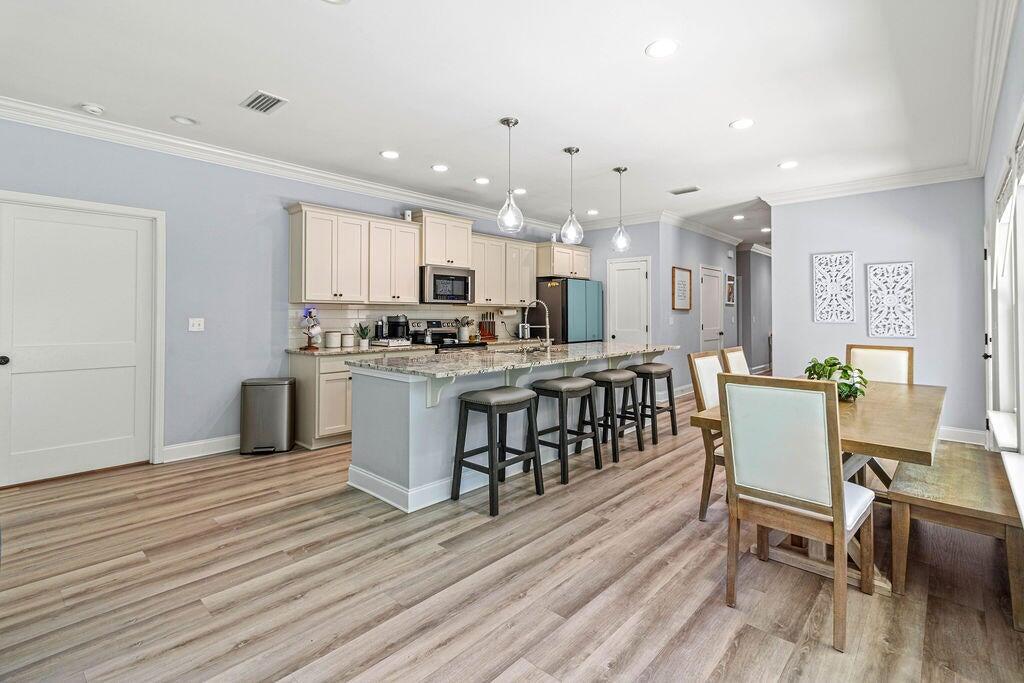 57 5th Street Shalimar, FL 32579 - Photo 8 of 31 a kitchen with stainless steel appliances a dining table chairs stove refrigerator and cabinets