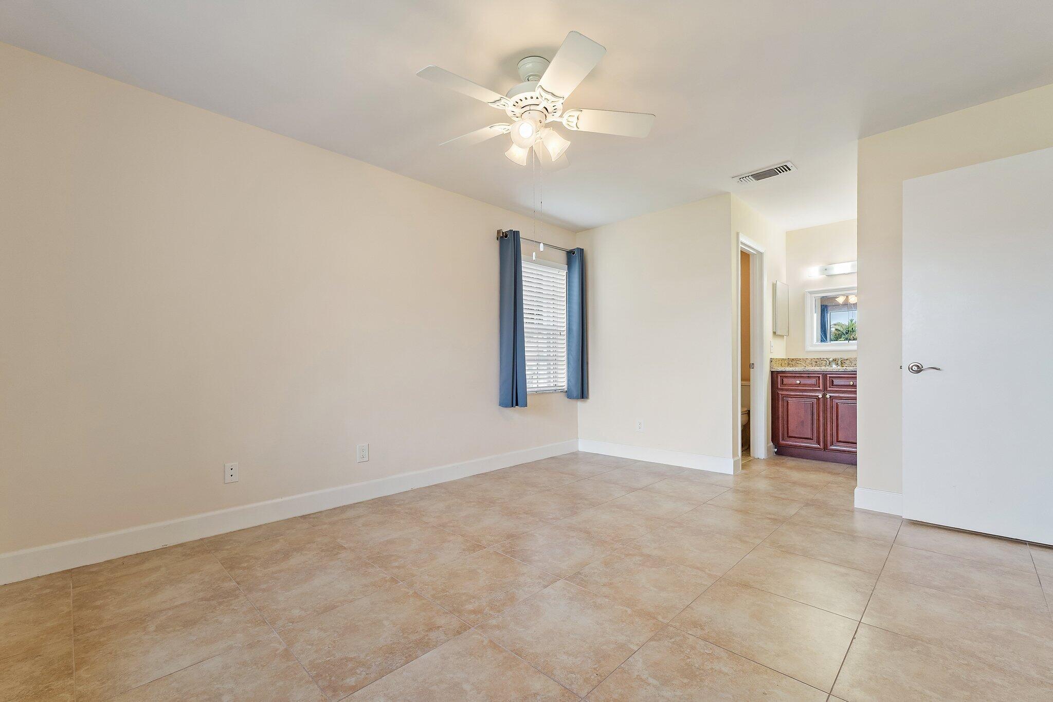 109 Doe Trail Jupiter, FL 33458 - Photo 12 of 26 wooden floor in an empty room with a ceiling fan