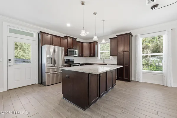 a kitchen with stainless steel appliances granite countertop wooden cabinets and a stove top oven