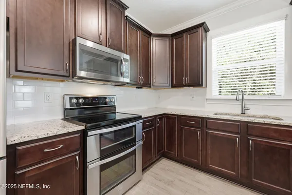 a kitchen with granite countertop wooden cabinets and stainless steel appliances