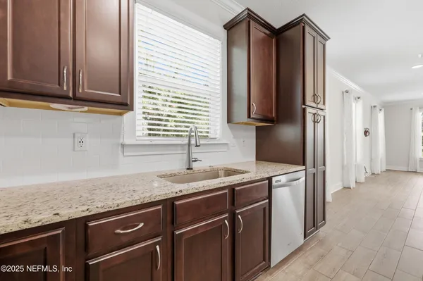 a kitchen with granite countertop cabinets stainless steel appliances and a sink
