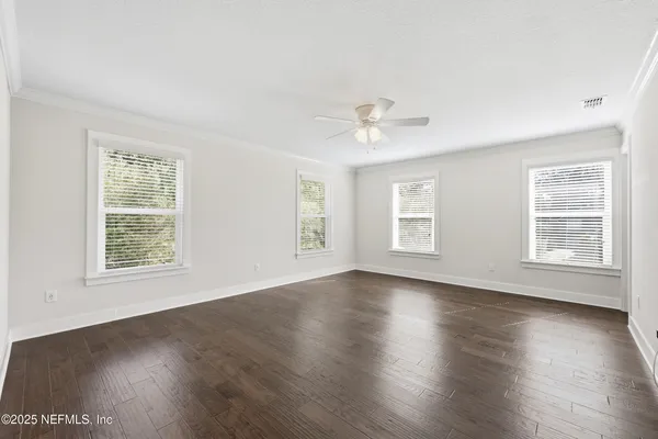 a view of an empty room with wooden floor