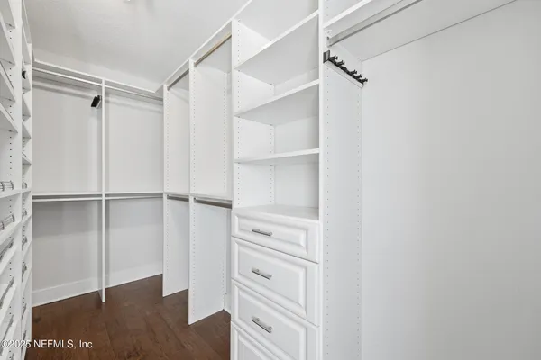 an empty room with a ceiling fan and wooden floor
