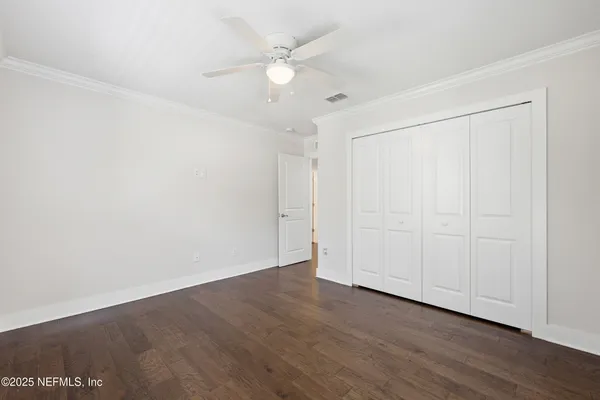 an empty room with wooden floor & windows
