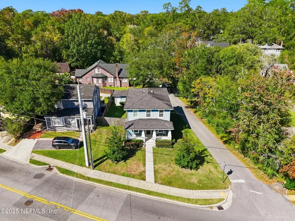 an aerial view of a house with a yard and lake view