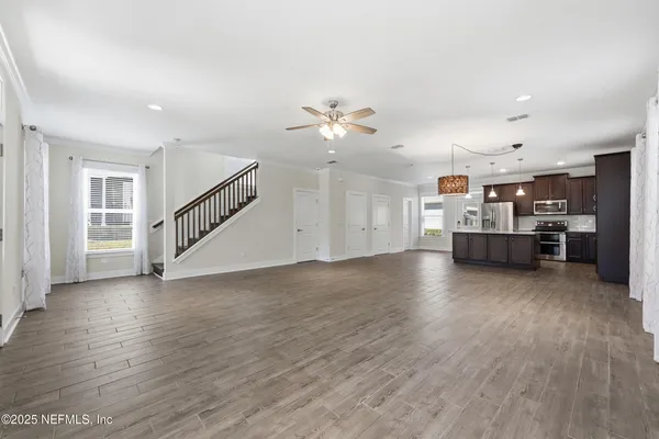 a kitchen with stainless steel appliances granite countertop a stove a sink dishwasher a refrigerator and a oven with wooden floor