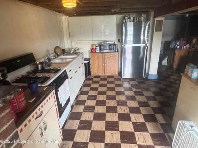a kitchen with a checkered floor and a refrigerator