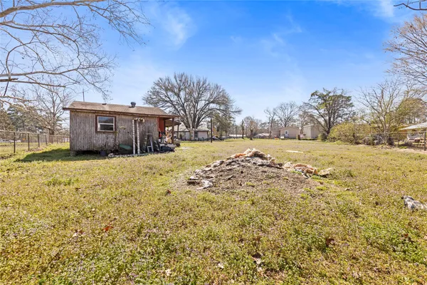 a view of a yard with an house and wooden fence