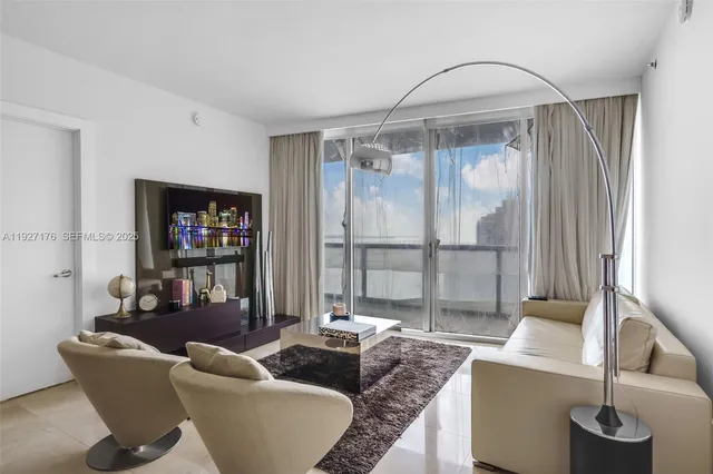 a living room with furniture and a glass door