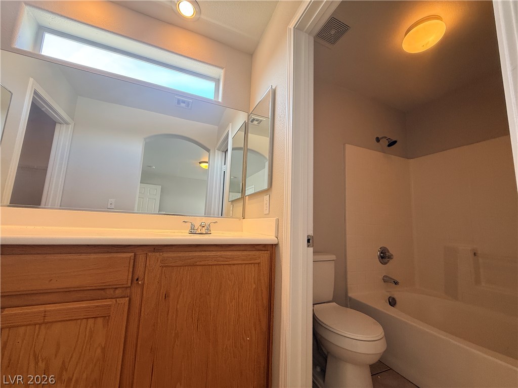 11953 Fairfax Ridge Street Las Vegas, NV 89183 - Photo 26 of 32 A well-lit bathroom features a vanity with ample counter space and an adjacent shower-tub combination.
