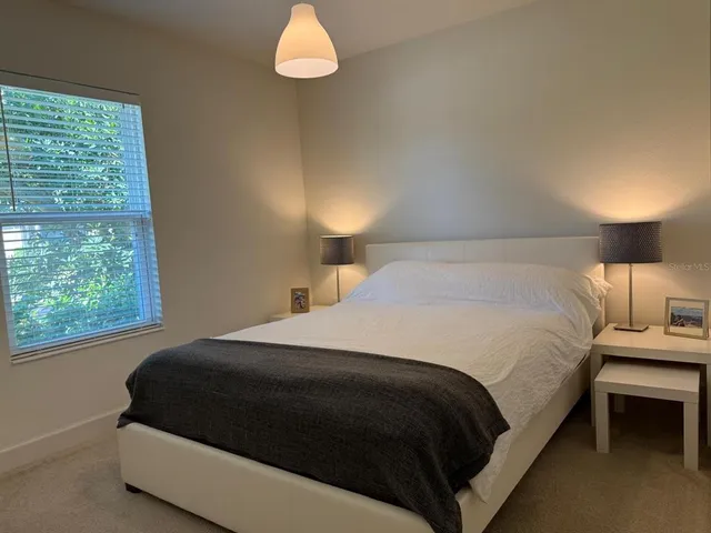 a bedroom with a bed lamp and window